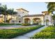 Grand entrance to the community featuring an arched entryway, lush greenery, and well-maintained sidewalks at 20398 Lagente Cir, Venice, FL 34293