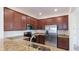 Modern kitchen with stainless steel appliances, granite countertops, and wood cabinets at 20398 Lagente Cir, Venice, FL 34293