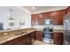 Stylish kitchen with stainless steel appliances, granite countertops, and dark wood cabinetry at 20398 Lagente Cir, Venice, FL 34293