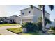 Exterior of home with landscaped front yard with green grass and palm trees at 215 63Rd E Dr, Bradenton, FL 34203