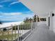 Spacious balcony with white railing, overlooking a pristine beach, the Gulf, and city condos at 2301 Gulf Of Mexico Dr # 36N, Longboat Key, FL 34228