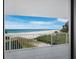 Balcony view of a white sand beach and turquoise ocean on a sunny day at 2301 Gulf Of Mexico Dr # 36N, Longboat Key, FL 34228