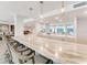 Elegant bar area with marble countertops, pendant lighting, and comfortable seating with views at 2301 Gulf Of Mexico Dr # 36N, Longboat Key, FL 34228