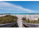 Picturesque beach scene featuring a wooden boardwalk, white sand, turquoise water, and a bright blue sky at 2301 Gulf Of Mexico Dr # 36N, Longboat Key, FL 34228