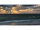 Scenic beach view with dramatic sun rays piercing through dark, moody clouds over the water at 2301 Gulf Of Mexico Dr # 36N, Longboat Key, FL 34228