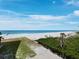 Beautiful oceanfront view of a white sand beach with palm trees on a sunny day at 2301 Gulf Of Mexico Dr # 36N, Longboat Key, FL 34228
