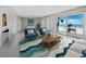 Comfortable living room with blue chairs, sliding doors, ocean view, chevron rug, and modern decor at 2301 Gulf Of Mexico Dr # 36N, Longboat Key, FL 34228