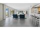 Bright living room with two blue chairs, a mirrored wall, tile flooring, and sliding glass doors leading to a balcony at 2301 Gulf Of Mexico Dr # 36N, Longboat Key, FL 34228