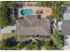 Aerial view of a property featuring a pool, patio, lush landscaping, and driveway at 2609 Webber St, Sarasota, FL 34239