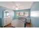 Blue bedroom features a ceiling fan and white dresser with a mirror and a bed with patterned bedding at 2609 Webber St, Sarasota, FL 34239