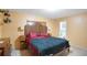 Cozy bedroom with yellow walls featuring a dark, ornate wooden headboard and carpeted floors at 2609 Webber St, Sarasota, FL 34239