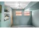 Light blue room with two windows, blinds, a ceiling fan, and shelving at 2609 Webber St, Sarasota, FL 34239