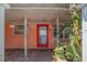 Charming front entrance with a red door, brick flooring, and lush greenery at 2609 Webber St, Sarasota, FL 34239