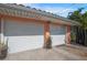 Two-car garage featuring white doors, coral-colored exterior, and concrete driveway at 2609 Webber St, Sarasota, FL 34239