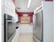 Well-lit kitchen with white cabinets and stainless steel refrigerator, featuring a sink with window at 2609 Webber St, Sarasota, FL 34239