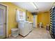 Laundry room with washer, dryer, toilet, and exterior access, tiled floor and yellow walls at 2609 Webber St, Sarasota, FL 34239