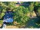 Aerial view of a property with mature trees, grassy yard, house, and a shed in the fenced backyard at 2906 Arlington St, Sarasota, FL 34239