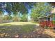 Spacious backyard featuring mature trees, a privacy fence, and a cozy deck for outdoor relaxation at 2906 Arlington St, Sarasota, FL 34239