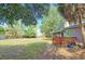 Exterior of home, showcasing a large backyard, cozy deck, mature trees and green door at 2906 Arlington St, Sarasota, FL 34239