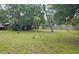 A home exterior with a large yard, mature trees, blue shed and privacy fence at 2906 Arlington St, Sarasota, FL 34239