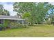 View of home with large yard, mature trees, and lush landscaping creates a peaceful setting at 2906 Arlington St, Sarasota, FL 34239