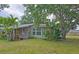 Charming single-story home featuring a bright green door, complemented by lush landscaping and mature trees at 2906 Arlington St, Sarasota, FL 34239
