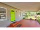 Inviting covered front porch with vibrant green door and views of the well-maintained front yard at 2906 Arlington St, Sarasota, FL 34239