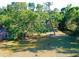 Spacious front yard featuring mature shade trees on a sunny day at 2906 Arlington St, Sarasota, FL 34239