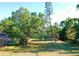 Spacious front yard featuring mature shade trees on a sunny day at 2906 Arlington St, Sarasota, FL 34239