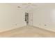 A bedroom with neutral carpet and walls features a ceiling fan and a doorway at 314 Pembroke Ln # 189, Venice, FL 34293