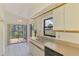Charming kitchen with white cabinetry, tiled floors, and a view of the backyard at 314 Pembroke Ln # 189, Venice, FL 34293