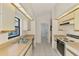 Functional kitchen featuring white cabinets, tiled floors, and plenty of counter space at 314 Pembroke Ln # 189, Venice, FL 34293