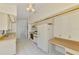 Functional kitchen featuring white cabinets, a tiled floor, and ample countertop space at 314 Pembroke Ln # 189, Venice, FL 34293