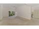 Spacious living room with neutral carpet, ceiling fan, and sliding glass doors to the outside at 314 Pembroke Ln # 189, Venice, FL 34293