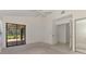 Bright bedroom with tile floors, a sliding glass door leading to lanai, and a view to ensuite bathroom at 314 Pembroke Ln # 189, Venice, FL 34293