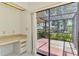 Bright office space featuring a built-in desk and access to a screened lanai with views of the lush outdoors at 314 Pembroke Ln # 189, Venice, FL 34293