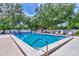 Community pool offers a refreshing swim and relaxation surrounded by lush greenery and ample seating at 314 Pembroke Ln # 189, Venice, FL 34293