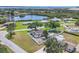 Aerial view of a home, showcasing its fenced yard, mature trees, and tranquil pond in the neighborhood at 322 Linden Dr, Ellenton, FL 34222