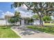 Charming single-story home featuring a well-manicured lawn, mature tree, and a two-car garage at 322 Linden Dr, Ellenton, FL 34222