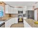 Well-lit kitchen features stainless steel appliances, granite counters, and white cabinetry at 322 Linden Dr, Ellenton, FL 34222