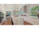 A kitchen with a marble topped island, stainless steel appliances, and hardwood floors at 3272 Bayou Rd, Longboat Key, FL 34228