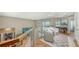Upstairs loft featuring comfortable seating, wood floors, and a glass railing at 3272 Bayou Rd, Longboat Key, FL 34228