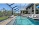 A screened-in pool with tiled trim is surrounded by lounge chairs and offers stunning views at 3272 Bayou Rd, Longboat Key, FL 34228