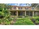 Charming backyard view with a screened lanai, green grass, and tropical plants at 3623 Square West Ln # 5, Sarasota, FL 34238
