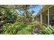 Picturesque backyard featuring green grass, lush plants, and views of a screened lanai and pond at 3623 Square West Ln # 5, Sarasota, FL 34238