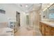 Bright bathroom featuring a large bathtub, glass-enclosed shower, and double wooden vanity at 3623 Square West Ln # 5, Sarasota, FL 34238