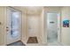 Spacious foyer featuring a glass front door, tile floors, and access to a half bathroom at 3623 Square West Ln # 5, Sarasota, FL 34238