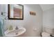 Half bathroom featuring a sink, mirror, toilet, and a decorative wall painting at 3623 Square West Ln # 5, Sarasota, FL 34238
