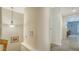 Hallway featuring neutral walls, tile flooring, decorative artwork, and a view into an adjacent light blue room at 3623 Square West Ln # 5, Sarasota, FL 34238