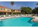 Community pool with plenty of seating, surrounded by lush tropical landscaping at 3623 Square West Ln # 5, Sarasota, FL 34238